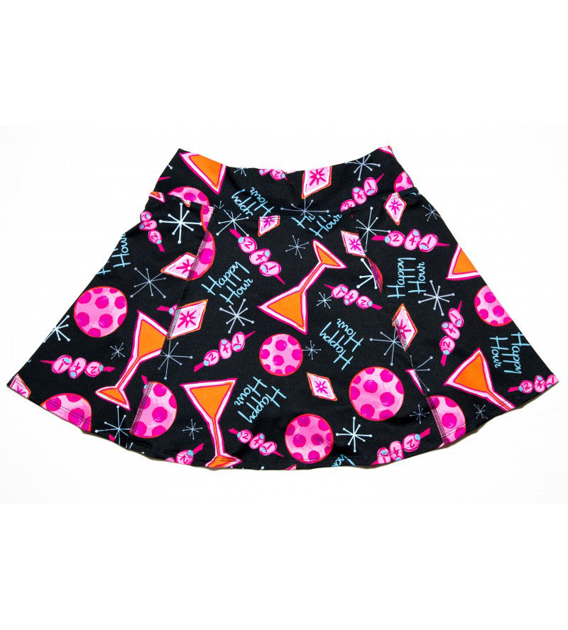 The Pickleball Bella PB Aline Skort Martini 2-4-1 Happy Hour features a flared black design with playful martini and polka-dot prints, red cocktail glasses, lips, starbursts, and "Happy Hour" text for a vibrant retro vibe.