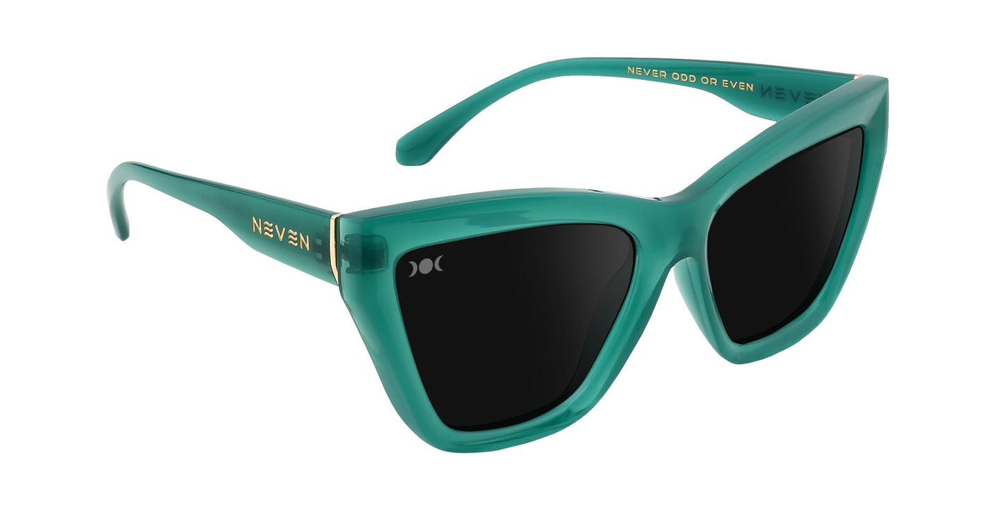 The Iris sunglasses by Neven Eyewear feature thick, glossy teal green cat-eye frames with dark polarized UV400 lenses, gold “NEVEN” on the left arm, and “NEVER ODD OR EVEN.” inside the right. Bold, modern statement eyewear.