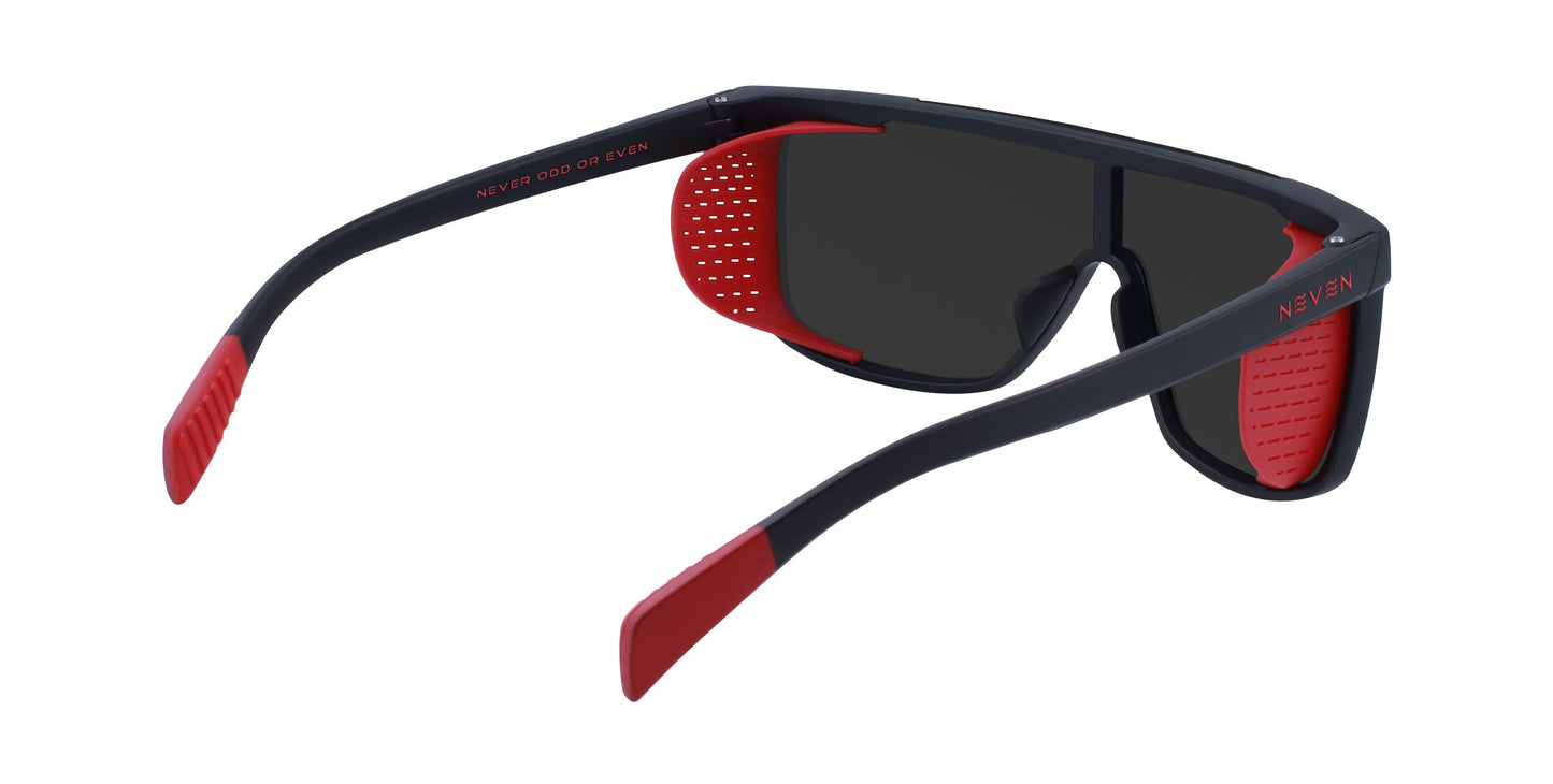 The Neven Eyewear Blood Moon sunglasses are sporty black frames with red accents, perforated removable side shields, and “NEVER ODD OR EVEN” on the inside left arm. They feature impact-resistant lenses for extra durability.