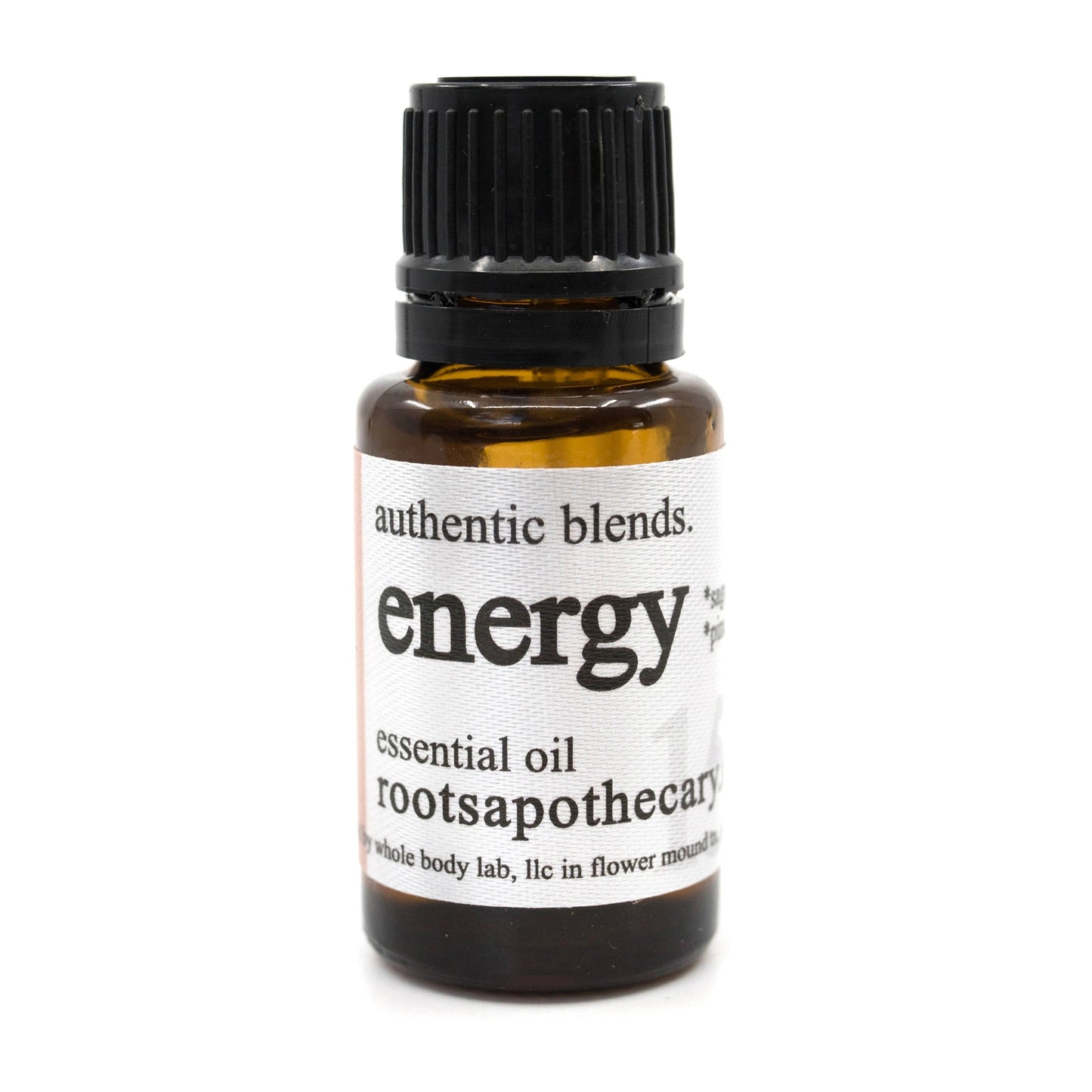 A small amber glass bottle with a black cap and white label reads “Roots Apothecary energy essential oil blend.” Infused with aromatic rosemary, it contains a revitalizing essential oil blend.