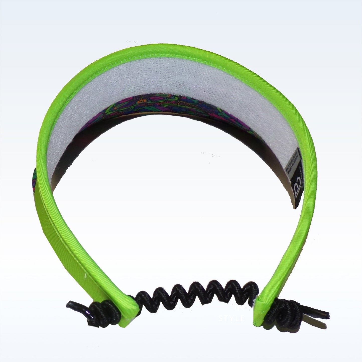 The PB Visor Groovy by Pickleball Bella features a neon green groovy print, gray moisture-wicking headband, colorful patterned underside, and a black coiled cord with knots at the ends. Shown from above on a plain white background.