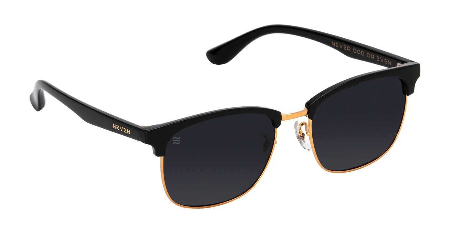 The Gold Rush by Neven Eyewear are black and gold clubmaster TR90 sunglasses with dark, impact-resistant lenses. Gold “NEVER EVEN” text appears on the temples; inside arm reads “NEVER ODD OR EVEN.” Clear nose pads for comfort.