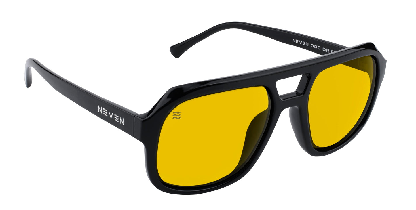 The Helios sunglasses by Neven Eyewear feature black, rectangular frames with thick arms and bright yellow-tinted lenses. “NEVEN” is printed in white on the left temple, and additional white text appears inside the right arm.
