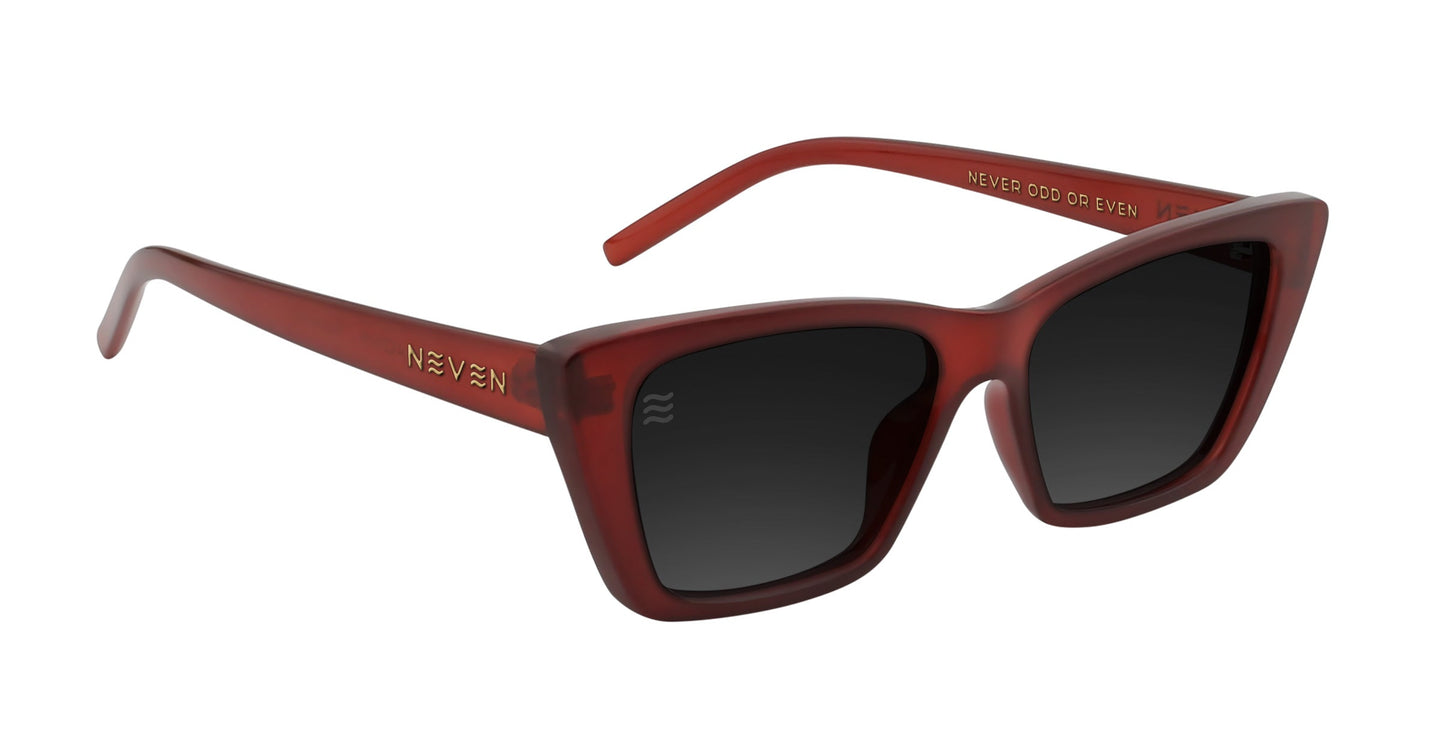 A pair of red cat-eye sunglasses, Espresso by Neven Eyewear, with dark polarized UV400 lenses. The glossy thick frame features “NEVEN” and “NEVER ODD OR EVEN” in gold on the arms. Set against a plain white background.