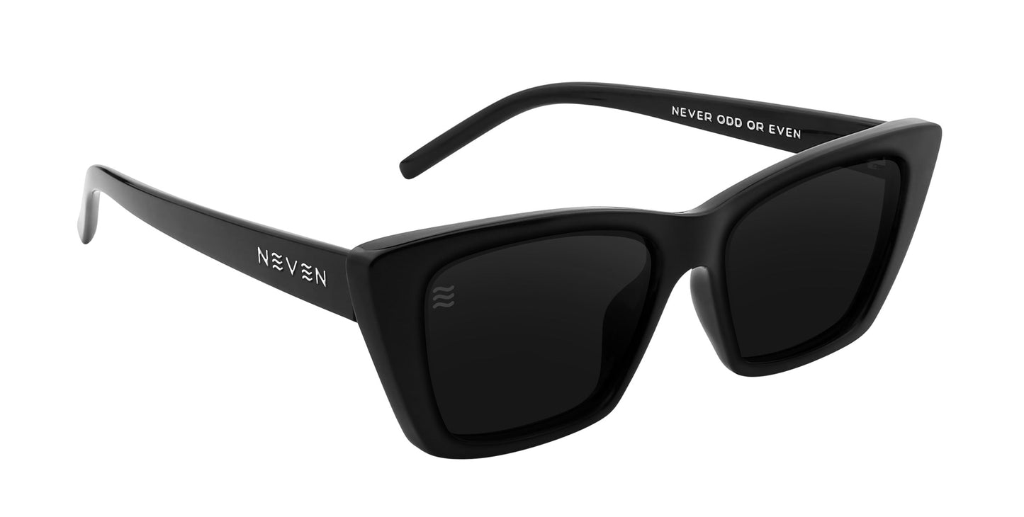 Noir by Neven Eyewear features thick, rectangular black frames with "NEVEN" in white on the left arm and "NEVER ODD OR EVEN" on the right. Polarized UV400 dark lenses provide a bold, modern style with French-inspired elegance.