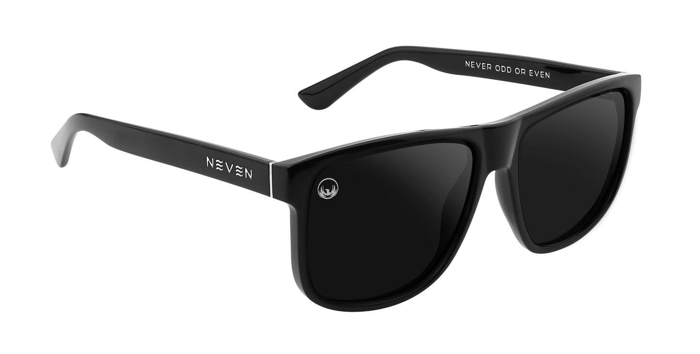 The Triumph sunglasses from Neven Eyewear feature black rectangular frames, polarized dark lenses, NEVEN in white on the left arm, and "NEVER ODD OR EVEN" inside the right arm. Worn by Zach Johnson.