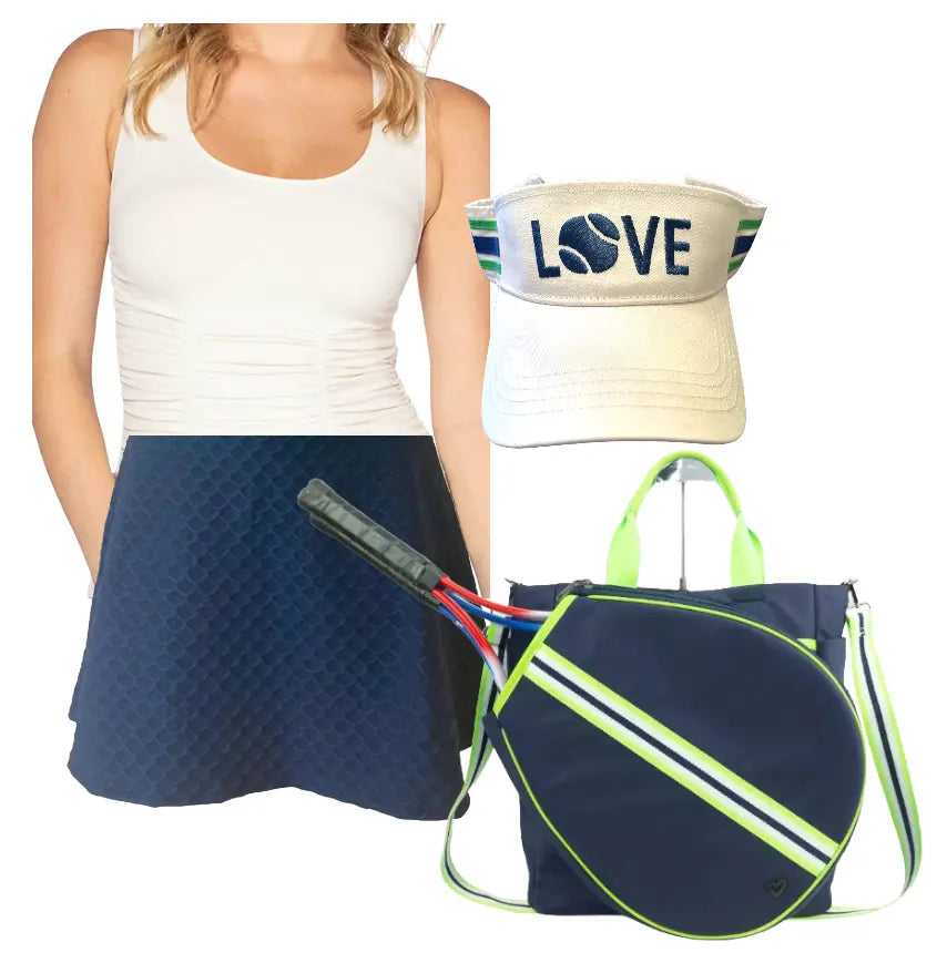 A woman wears a sleeveless white tennis top and the Nola Navy Blue Scallop Skirt by Runway Athletics, featuring a moisture-wicking under-short. Next to her are a “LOVE” tennis ball visor and a navy bag with neon green accents holding two rackets.