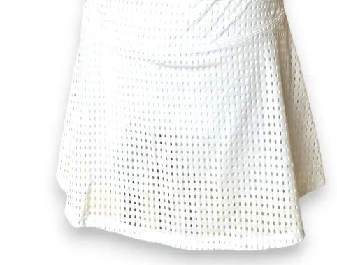 The Mesh Club Set - White by Runway Athletics is a flared athletic skirt set with a mesh-like pattern of square holes, a gathered waistband, and soft drape for an airy, casual look ideal for any activity.