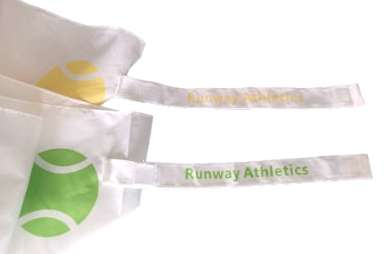 Two white fabric face masks, each featuring a stylized tennis ball (one yellow, one green) and Runway Athletics straps in matching colors, pair perfectly with the Runway Athletics Umbrella - Yellow Tennis Balls.