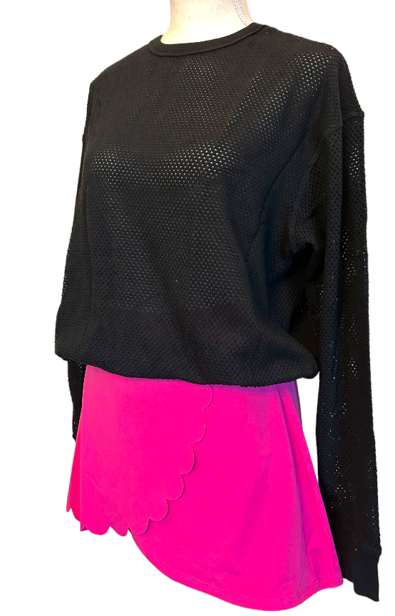 A mannequin sports the Mesh Pullover - Black by Runway Athletics, featuring a loose fit and adjustable drawstring hem, paired with a scalloped-edge pink skirt for bold court style against a plain white background.