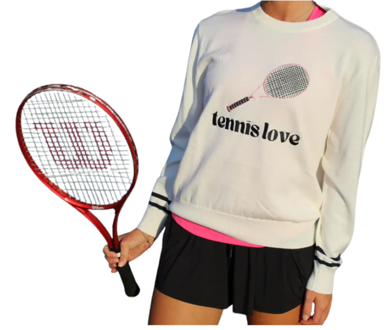 A person wears the Runway Athletics Tennis Sweater - Tennis Love with black shorts and a hot pink sports top, holding a red Wilson tennis racquet in their right hand. Background removed.