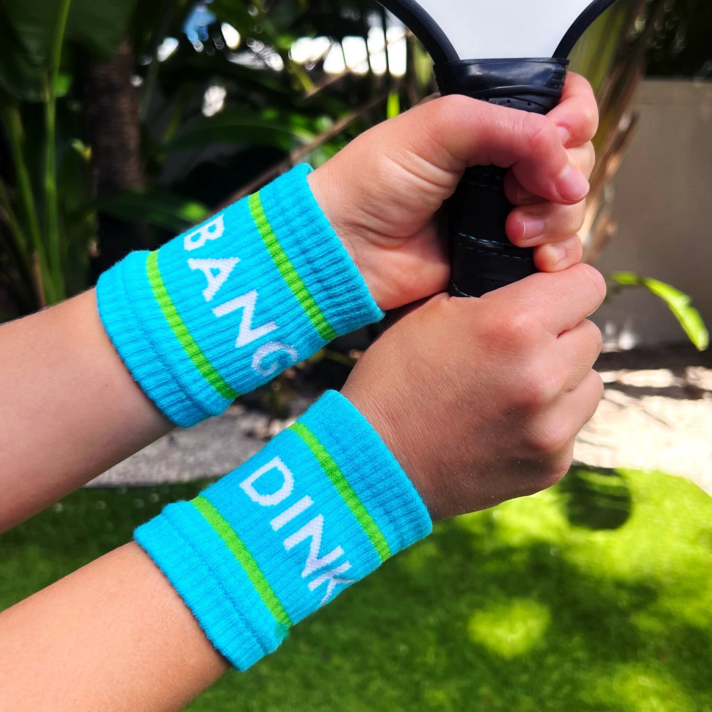 A player wears Blue Dink & Bang Pickleball Wristbands by Swinton Pickleball—essential court accessories for any match.