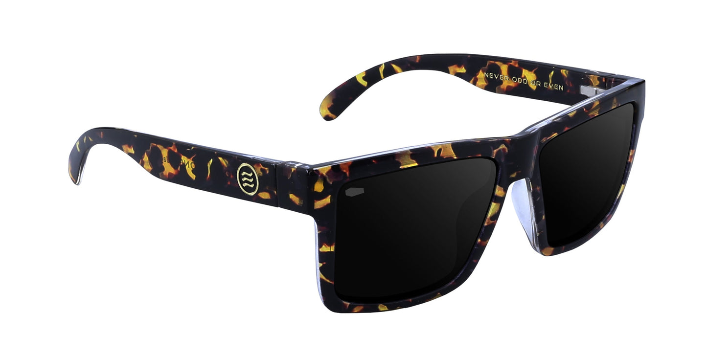 The Jaguar XL sunglasses by Neven Eyewear feature thick, rectangular dark tortoiseshell frames and polarized UV400 black lenses. The left arm displays a circular logo; the right arm shows gold “NEVER LOOK BACK” text.