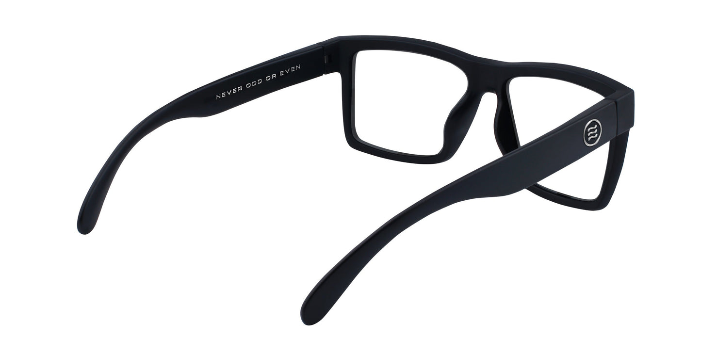 A pair of black rectangular Malibu frames by Neven Eyewear is shown from the back with open, curved arms. "NEVER ODD OR EVEN" is printed in white inside the left arm—a stylish nod to clear motorcycle glasses.