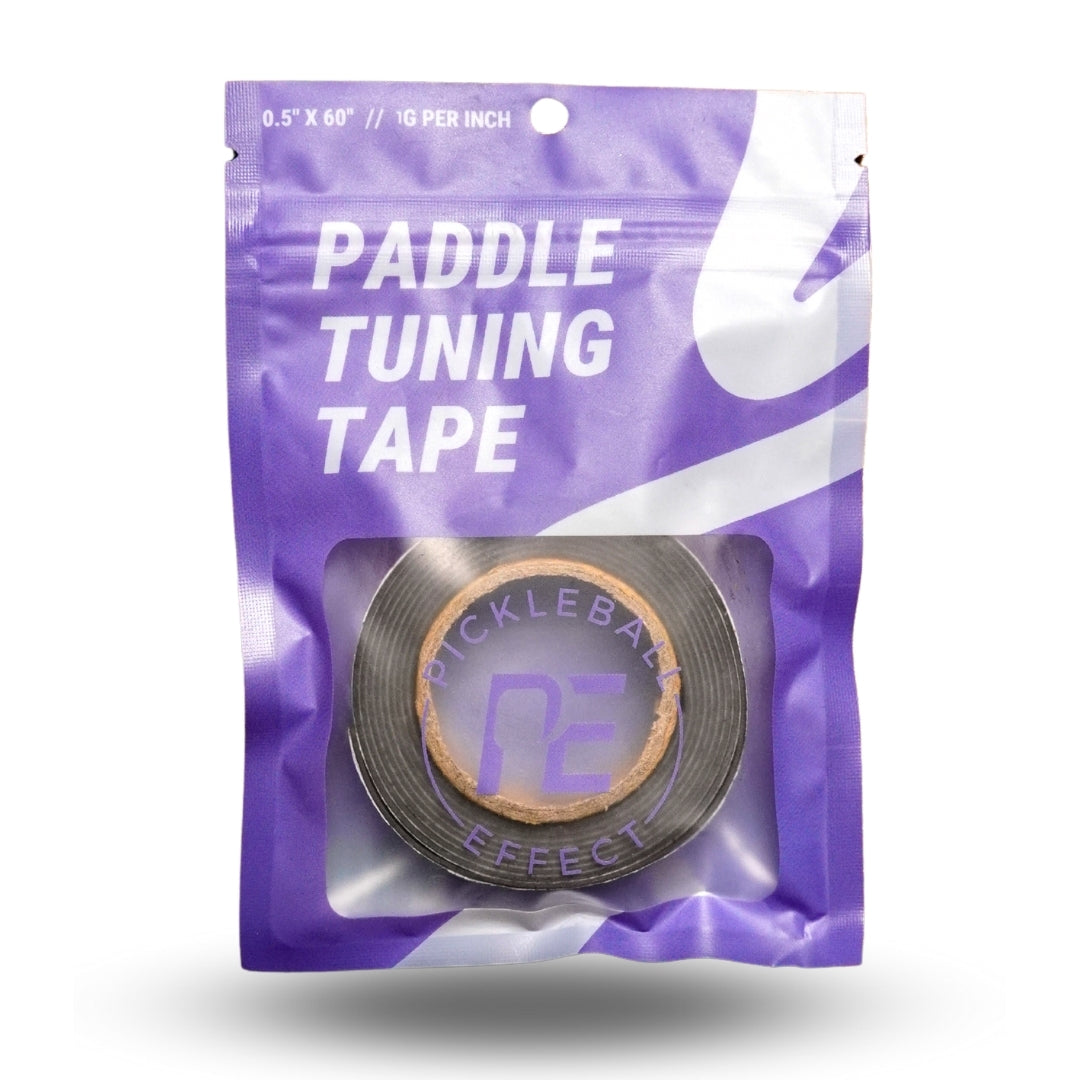 Pickleball Effect Shop Paddle Tuning Tape comes as a roll of black tape in a purple resealable pouch labeled “PADDLE TUNING TAPE” in bold white, with a clear window—great for adjusting pickleball paddle weight and balance.