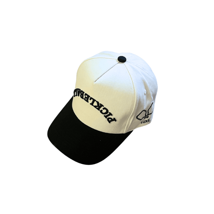 The LUXE Pickleball Hat features a white crown, black brim, black embroidered "PICKLEBALL" text, sun protection, and a paddle-and-ball side graphic with "LUXE" for extra style.