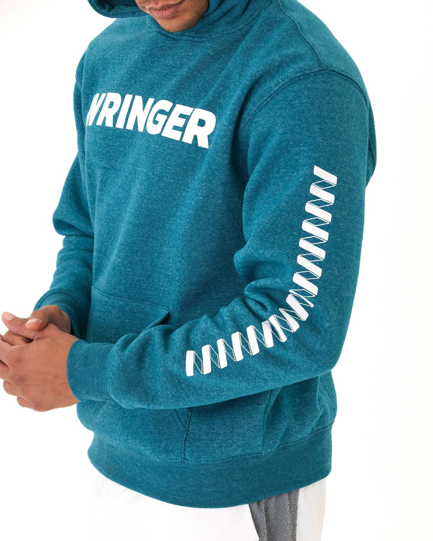 A person models the Men's Core Wringer Graphic Hoodie by Wringer Wear in teal, featuring bold white "WRINGER" lettering on the chest and diagonal white stripes on one sleeve; only their lower face and torso are visible against a white background.