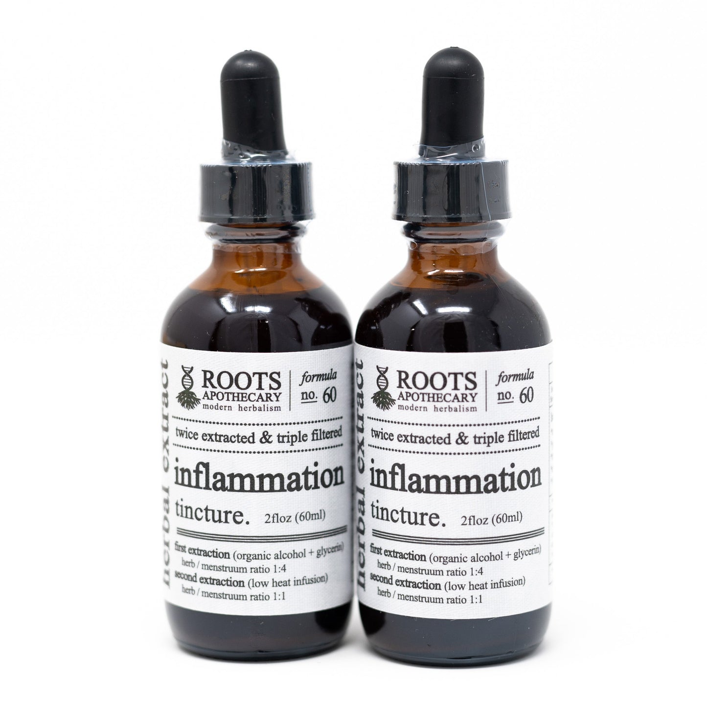 Two brown glass dropper bottles of Roots Apothecary Inflammation Tincture stand side by side. The white labels display dosage info in black text. The background is plain white.