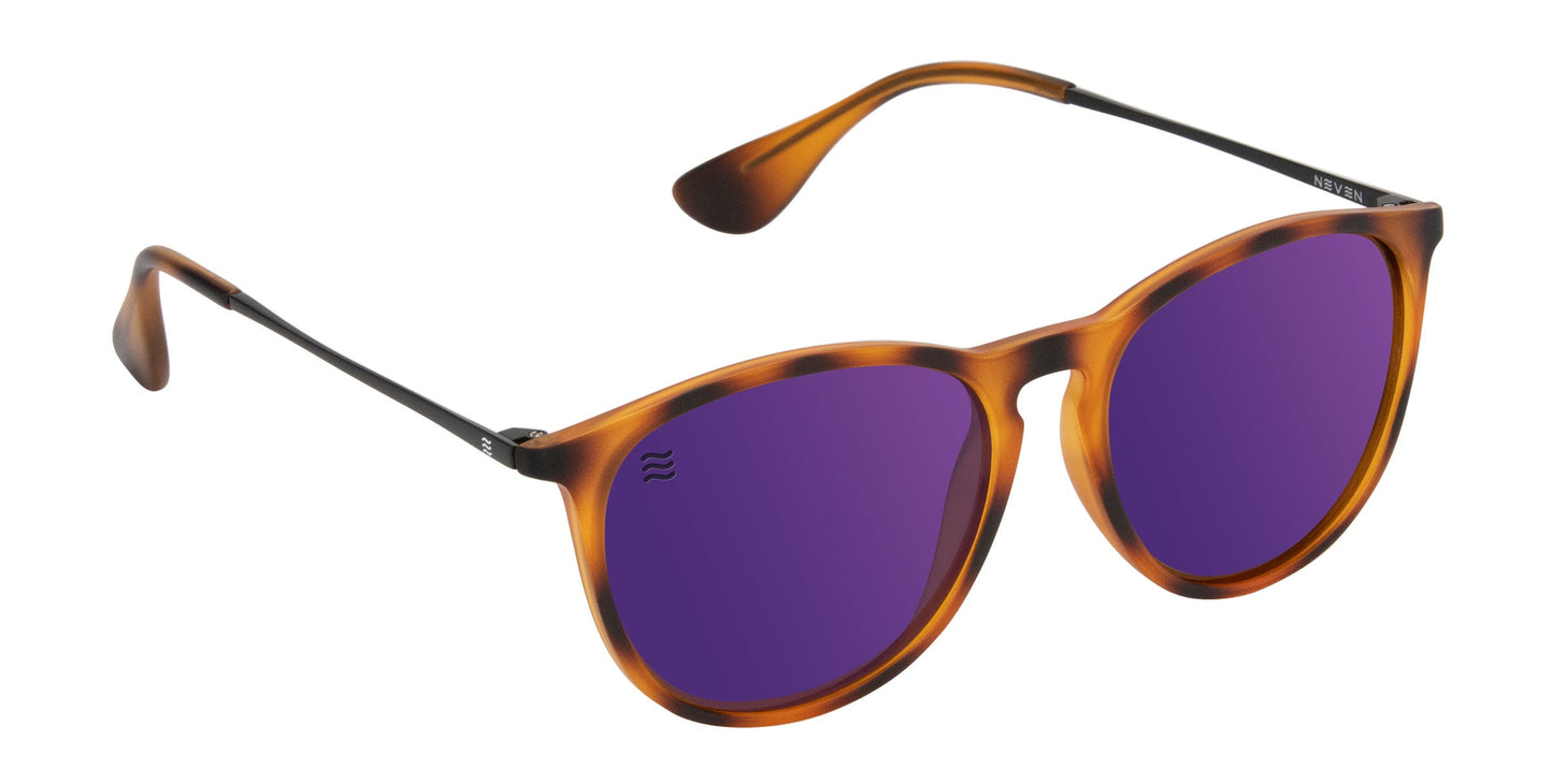 Stella by Neven Eyewear: Round sunglasses with polarized dark purple UV400 lenses, matte tortoiseshell TR90 frame, thin black arms, and a subtle logo etched on the upper left lens. Shown on a plain white background.