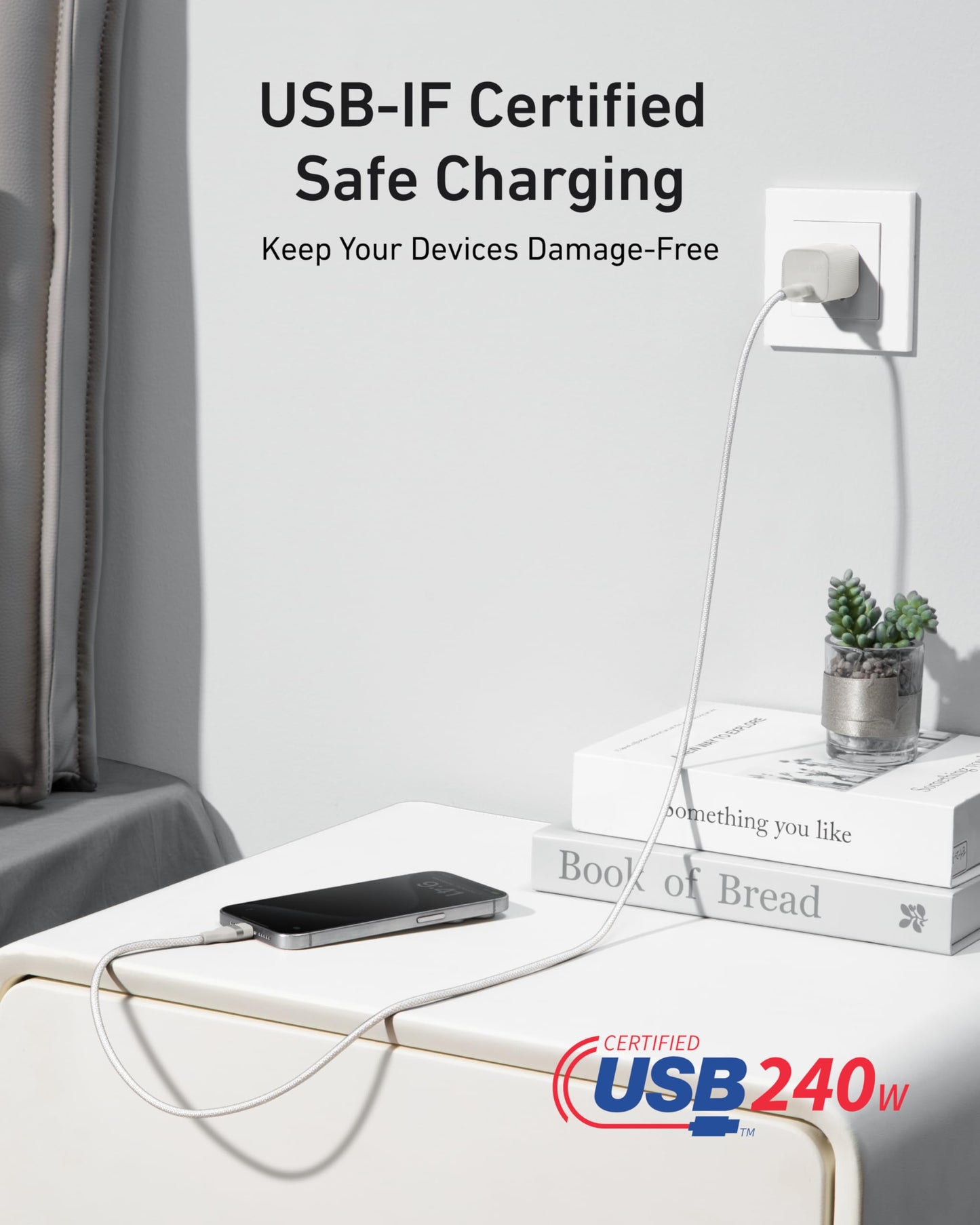 An Anker USB-C to USB-C Cable (3 ft, 240W, Upcycled-Braided) powers a phone on a white nightstand with two books and a potted plant. Text: “USB-IF Certified Safe Charging—Keep Your Devices Damage-Free.”.
