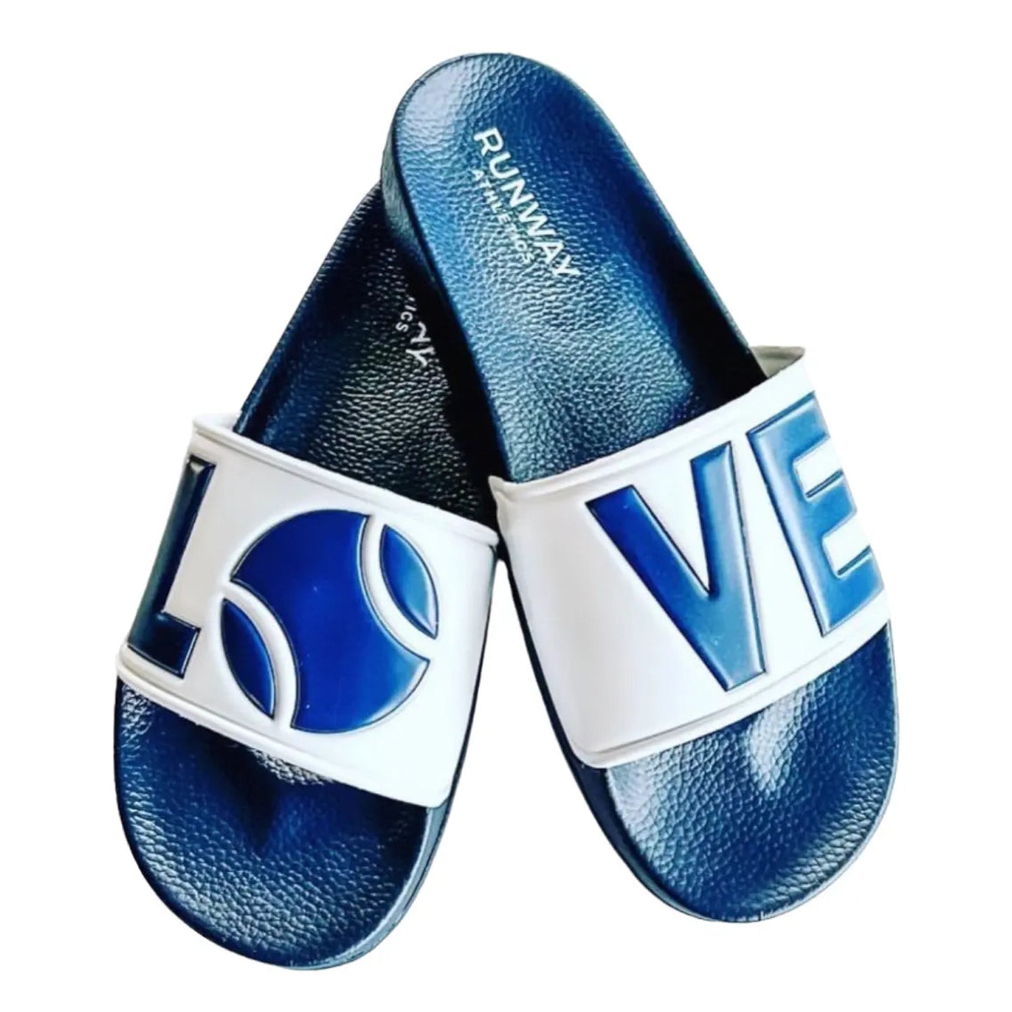 The Tennis LOVE After Play Tennis Slides by Runway Athletics feature navy blue textured soles and white straps with embossed letters spelling LOVE and a tennis ball O. The brand is printed inside, making them a perfect tennis gift.