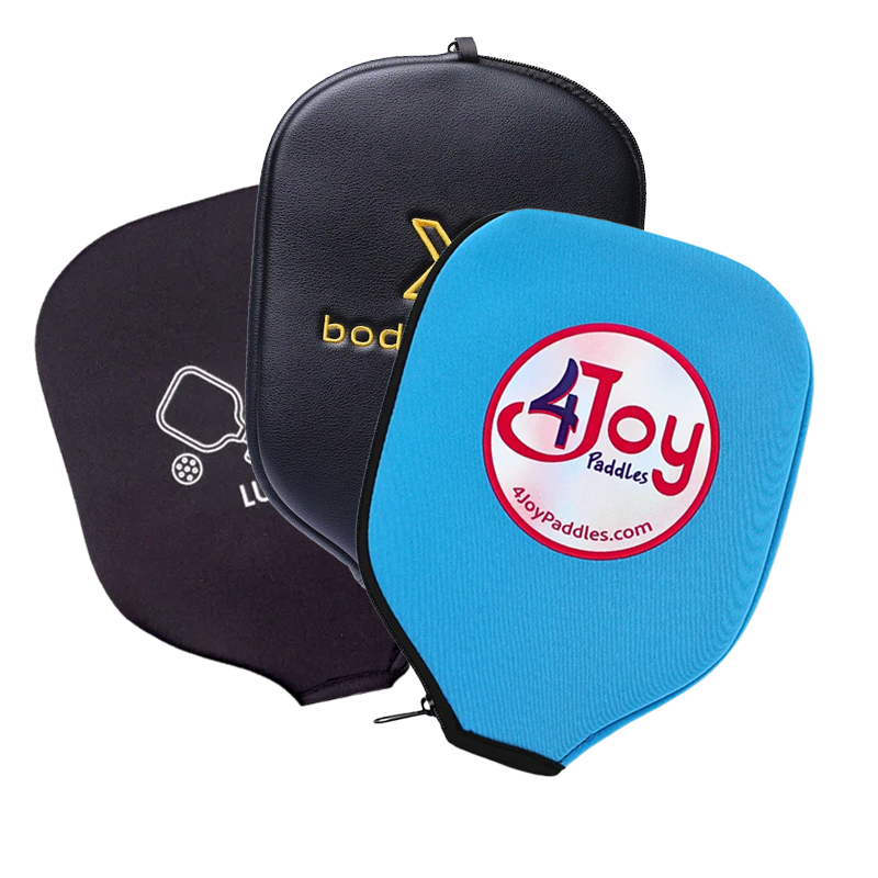 Three pickleball paddle covers in black and blue, each with a distinct logo, are overlapping. The front blue cover displays a red and white “4Joy Paddles” logo.