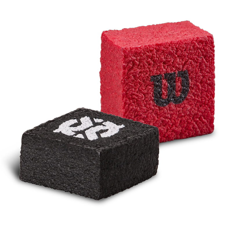 Two square, textured tennis racket grip enhancers are shown. One is black with a white “W” logo, and the other is red with a black “W” logo. Both have a rough, sponge-like surface.