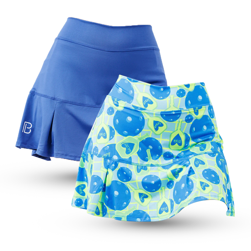 Two athletic skirts are displayed inside out, revealing shorts with playful prints: one is solid blue with blue-and-white planets; the other is black with colorful, retro atomic and space-themed patterns.