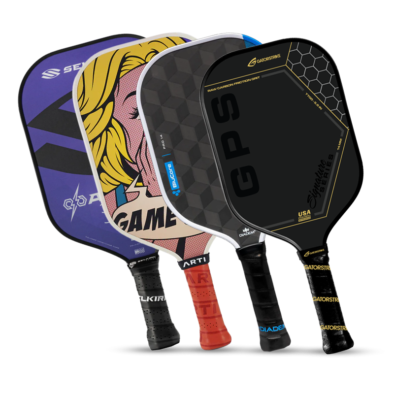 Four pickleball paddles with different designs stand upright. The designs include a pop art face, a hexagon pattern, bold text, and a purple paddle with angular graphics. All have black handles.