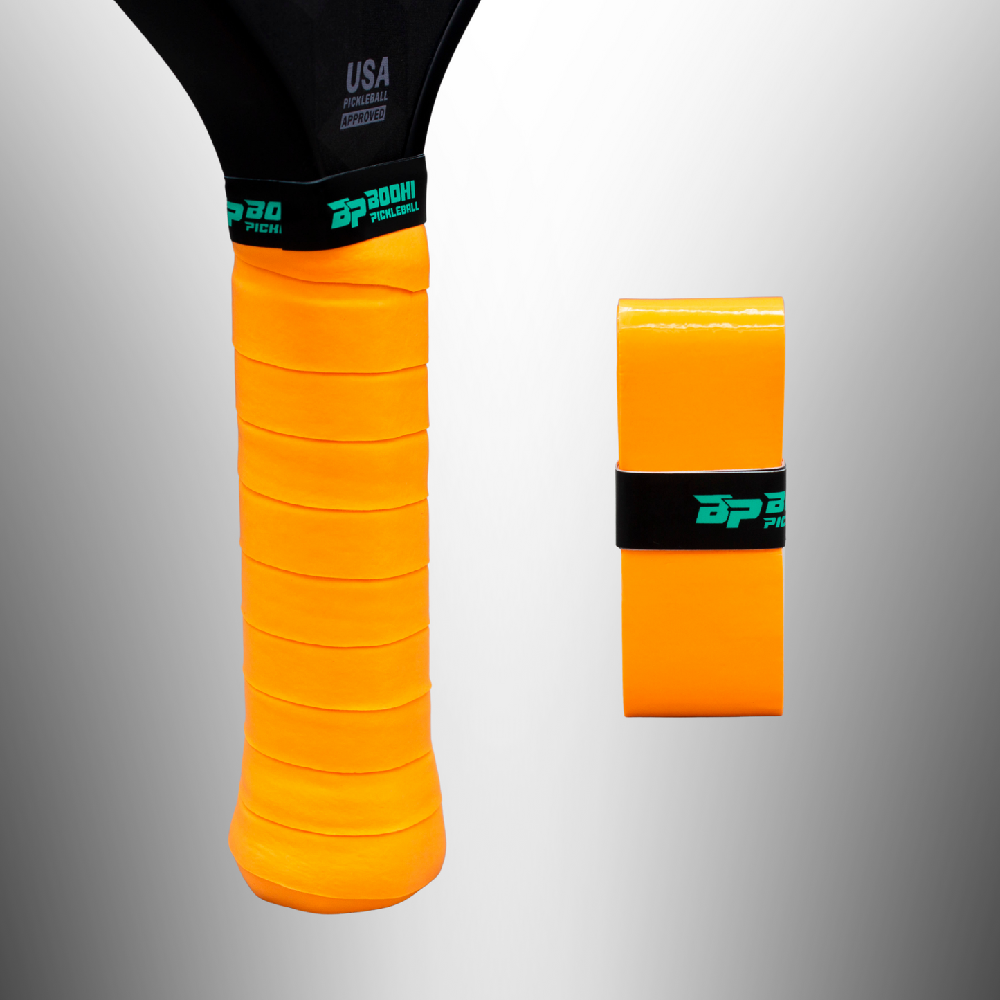 A close-up of a racquet handle wrapped in Bodhi Performance PROtack™ Premium Pickleball Overgrips in bright orange, with a black BP30 Pickleball band. Next to it stands an unused roll of matching overgrips, also secured by a black band.
