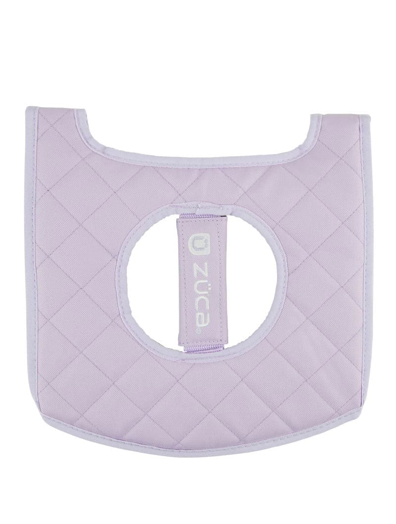 The ZUCA Reversible Seat Cushion is a light purple, quilted, square cushion with rounded edges and a central hole crossed by a logo strap. Soft and padded, it's designed for decorative or protective use on your seat.