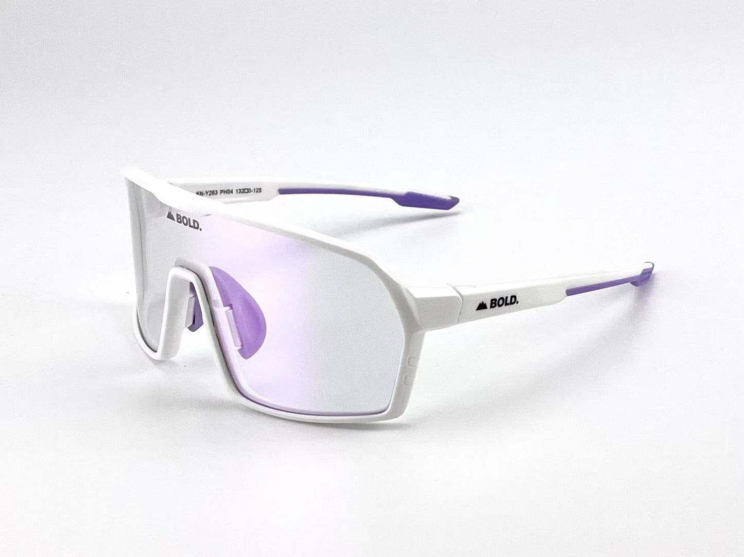The BOLD Drift Photochromic Sunglasses by boldouterwear feature a sporty oversized white frame, purple earpieces, and light purple lenses. “BOLD.” is printed on the arms. Shown against a plain white background.