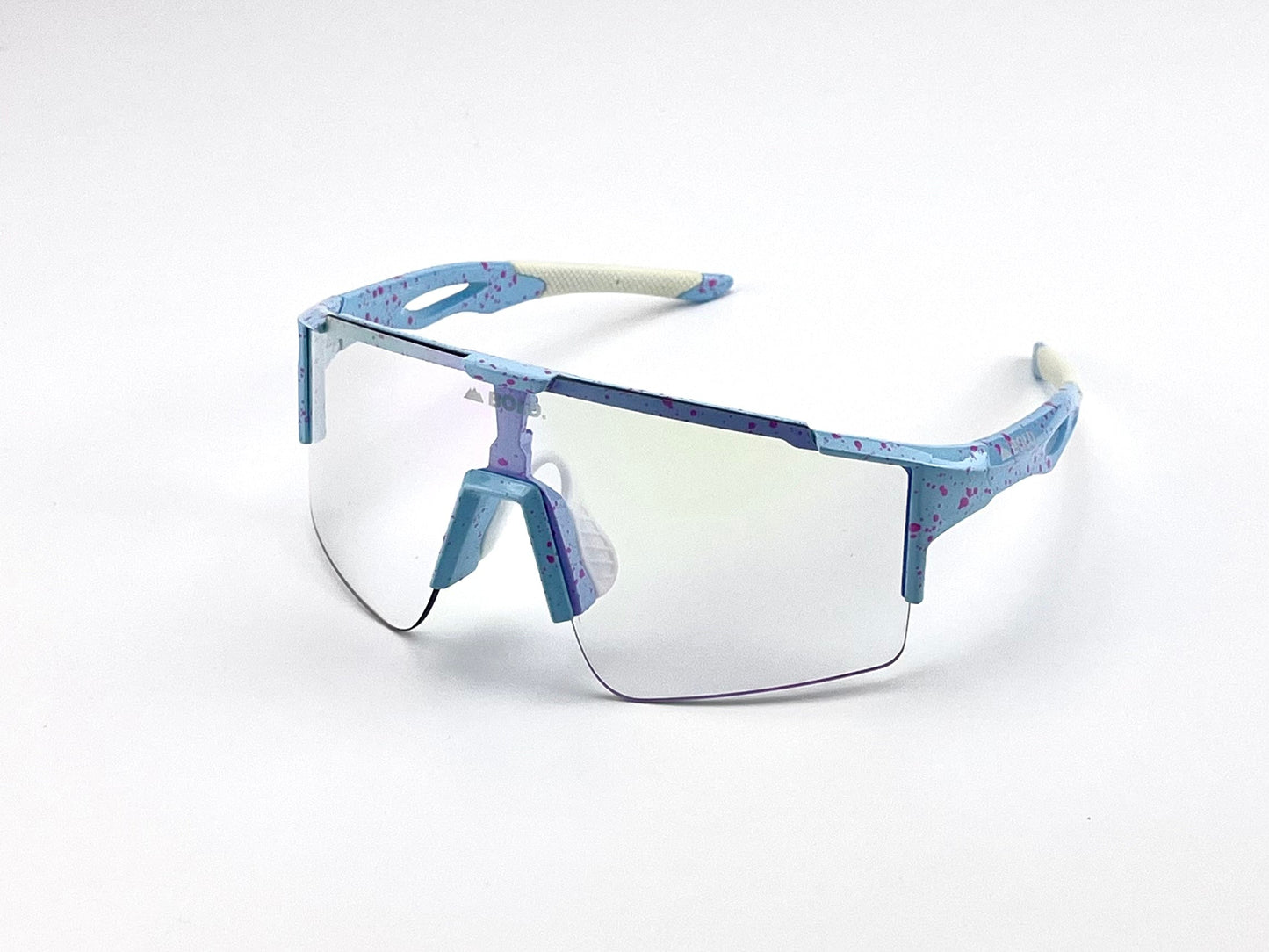 The BOLD Wavelength Performance Sunglasses by boldouterwear feature a single clear lens, blue frames with pink speckles, white nose pads, textured temple tips for grip, and are ideal for MTB, ski & lifestyle use. Shown on a plain white background.