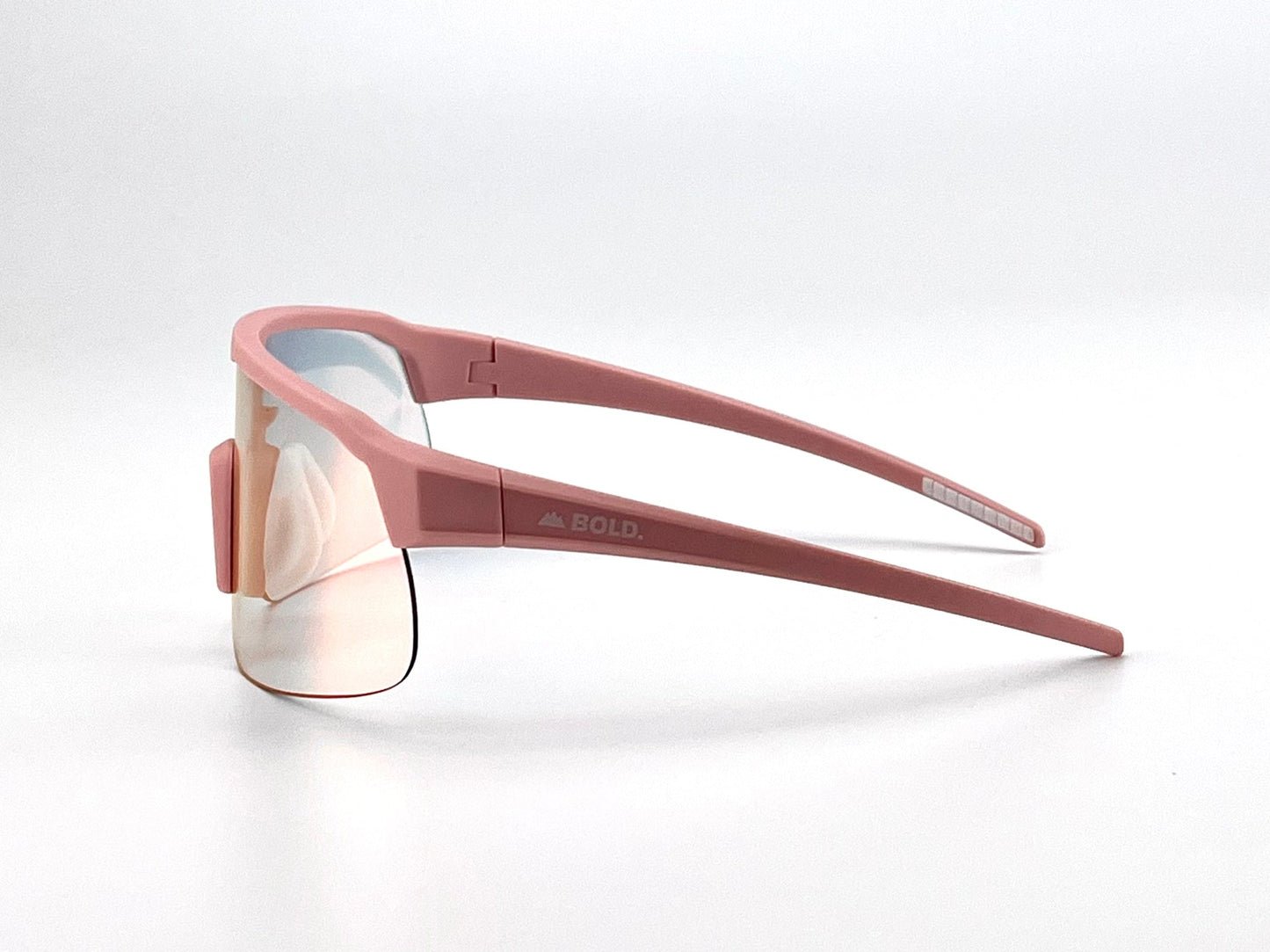 The BOLD Zippy Photochromic Sunglasses by boldouterwear feature sporty pink frames, slightly mirrored lenses, and "BOLD" on the left temple. Sleek, angular lines stand out against a plain white background for a modern look.