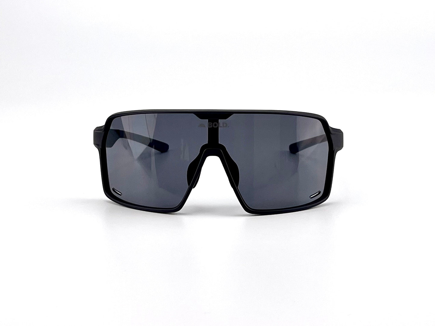 The BOLD Shadows Performance Sunglasses by boldouterwear, shown on a white background, feature a black shield-style wraparound design with a single wide fixed-tint lens and “BOLD” subtly visible on the sporty angular frame.