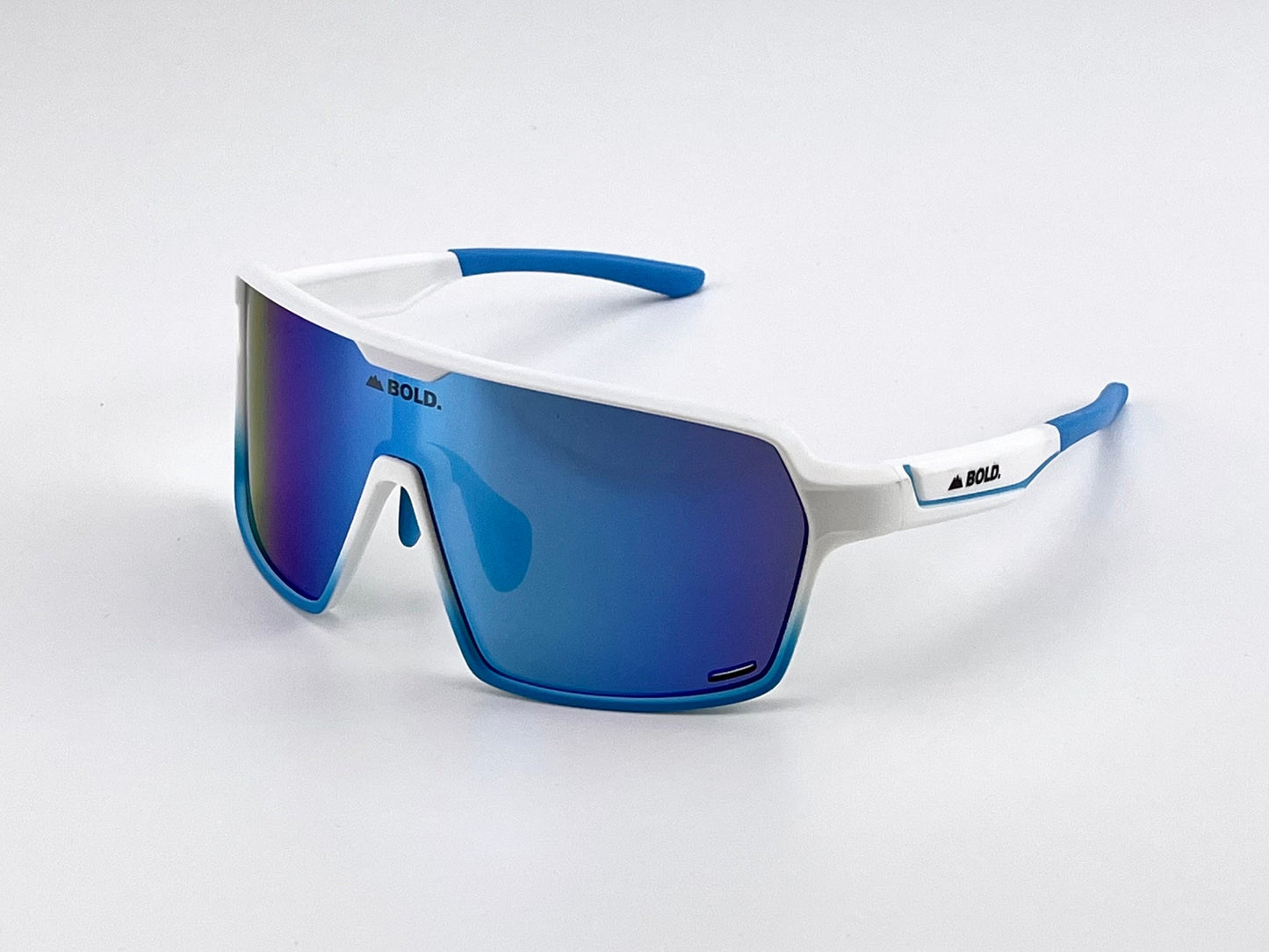 The BOLD Shadows Performance Sunglasses by boldouterwear feature a white frame, blue accents, and reflective blue lenses, with a sleek wraparound design and "BOLD." printed in black on the side—perfect for MTB, ski, or lifestyle use.