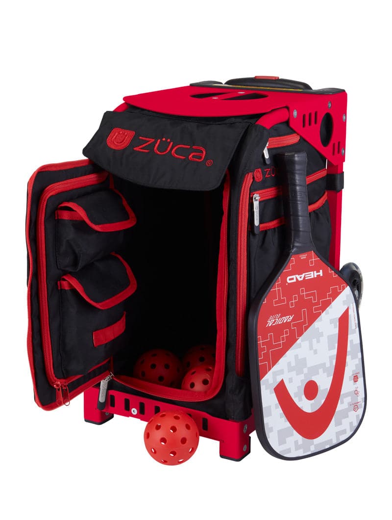 The ZUCA Pickleball Sport Black/Red rolling bag displays three orange pickleballs in its open front, features internal mesh pockets for gear storage, and includes a grey HEAD paddle with red accents in the side sleeve.