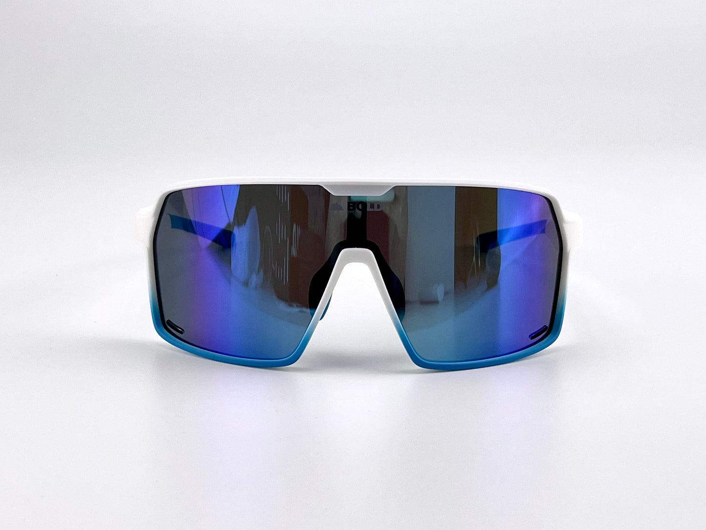 The BOLD Shadows Performance Sunglasses by boldouterwear feature a white frame with large, curved rectangular blue-tinted mirrored lenses that reflect purple and blue, designed for MTB, ski, and lifestyle use.