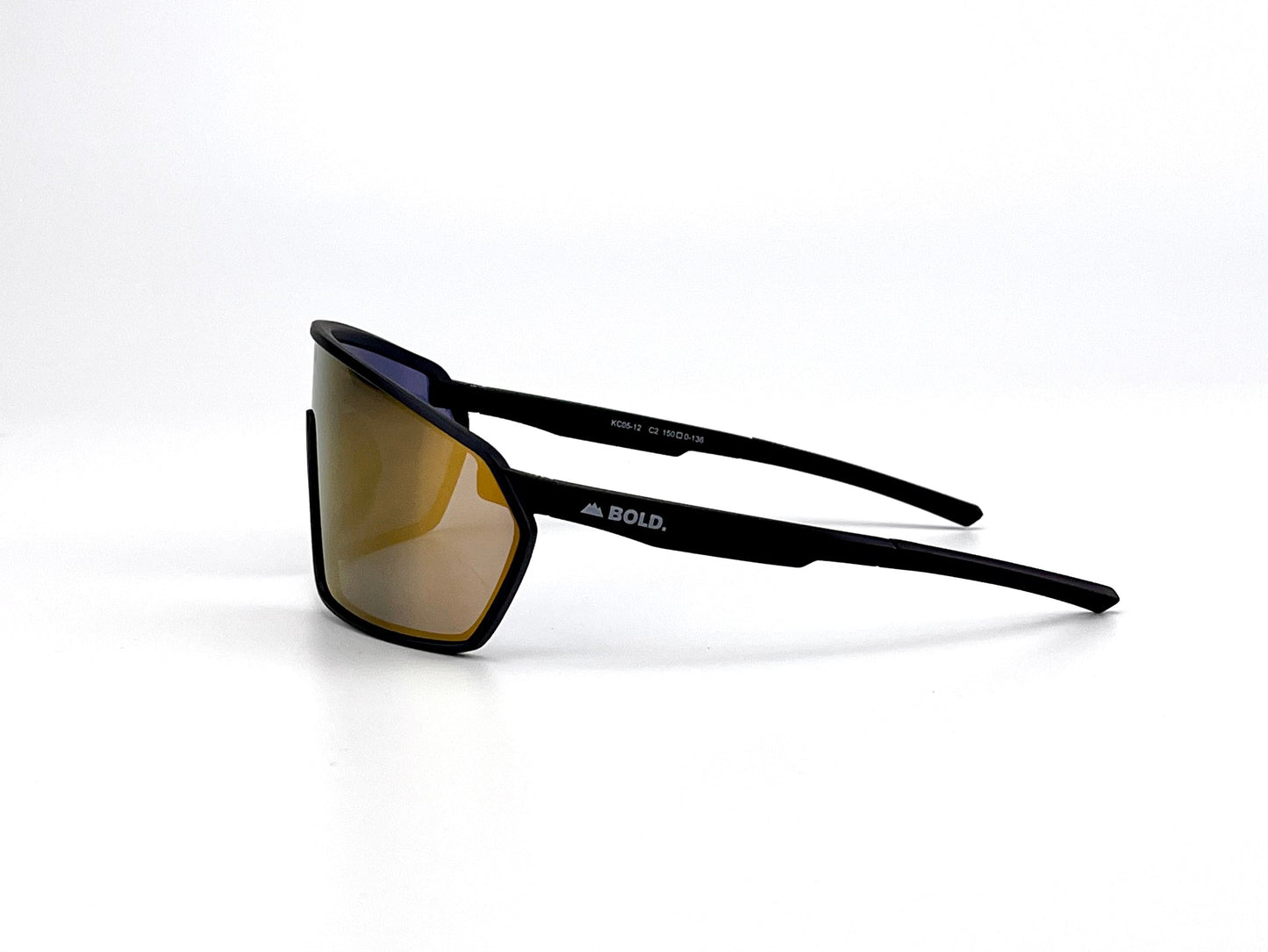 The BOLD NSP Performance Sunglasses by boldouterwear feature angular, oversized gold-tinted lenses and a matte black frame with the white BOLD. logo on the side arm. Shown in right profile on a plain white background.