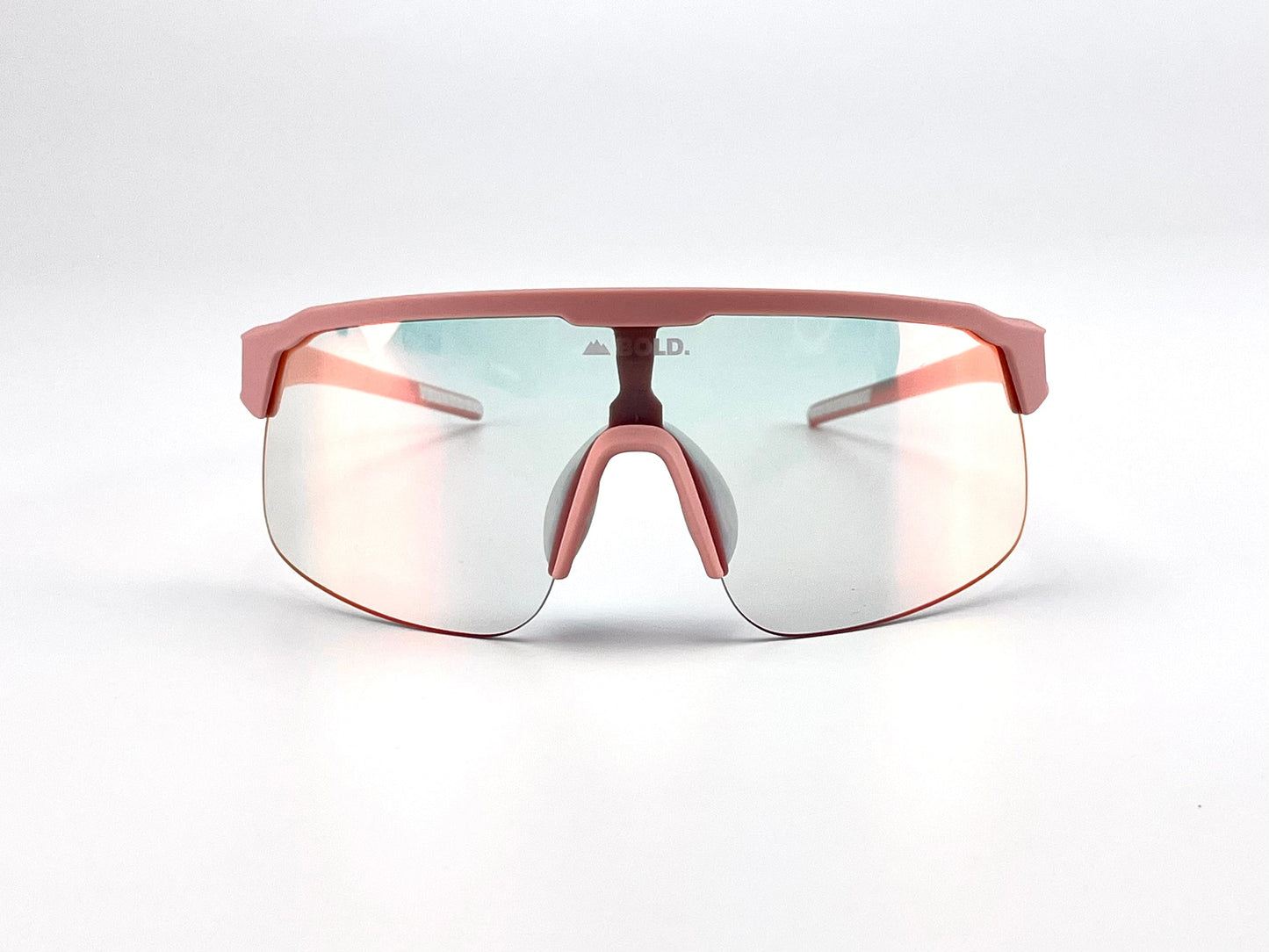 The BOLD Zippy Photochromic Sunglasses by boldouterwear feature a lightweight pink frame with large, lightly tinted reflective lenses and matching pink nose pads and arms. Shown facing forward on a plain white background. Suitable for MTB, ski, and lifestyle wear.