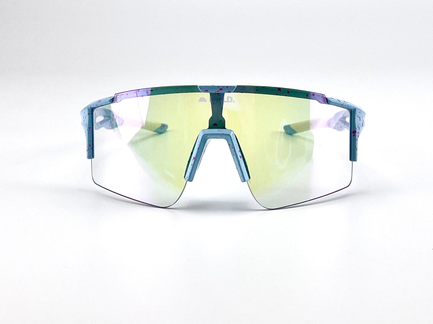 The boldouterwear BOLD Wavelength Performance Sunglasses feature a large, yellow-tinted wraparound lens and a blue frame with purple/red speckles—perfect for MTB, ski, or lifestyle use. Shown on a plain white background.