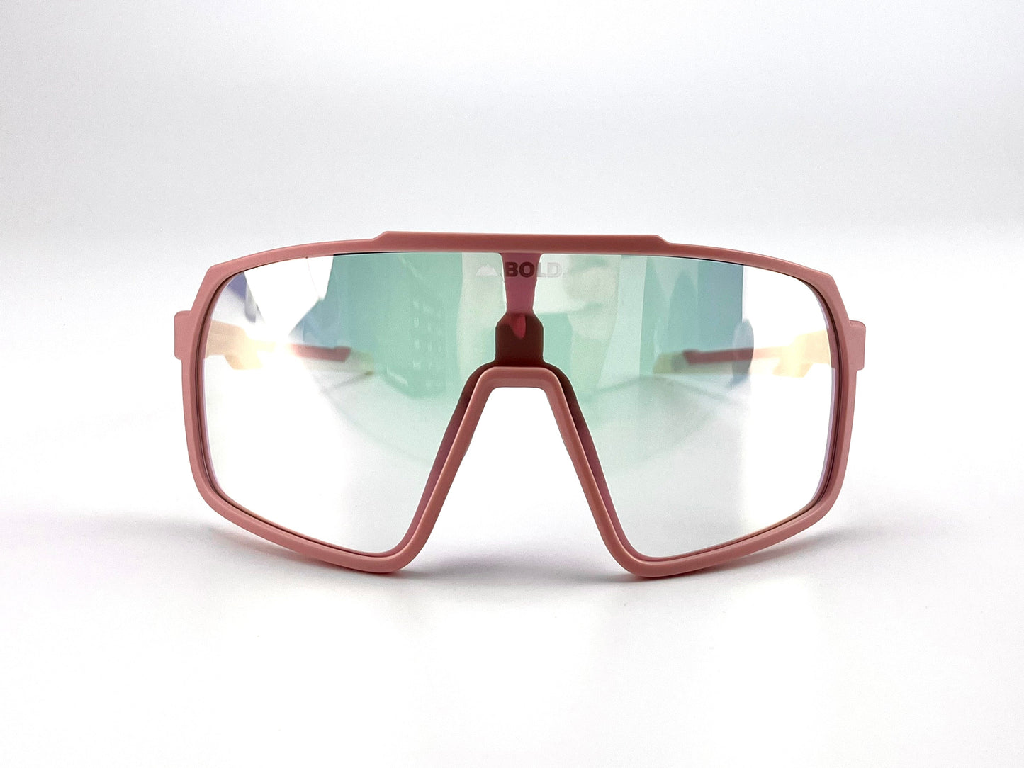 The BOLD Slayers Photochromic Sunglasses by boldouterwear feature a pink frame and mirrored green-tinted, light-adaptive wraparound lens. Displayed on a plain white background, these sports sunglasses showcase a bold and modern design.