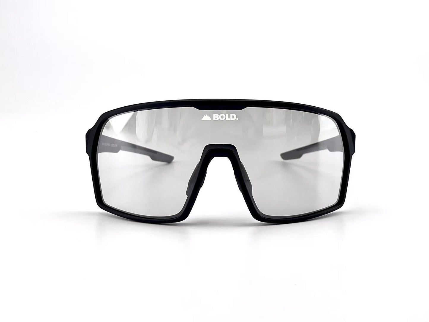 The BOLD Drift Photochromic Sunglasses by boldouterwear feature a sporty wraparound black frame, large lightly tinted lenses with "BOLD." and a mountain logo in white at the top center, set against a plain white background.