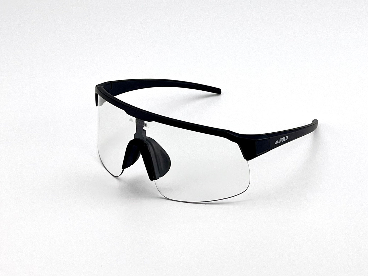 BOLD Zippy Photochromic Sunglasses by boldouterwear feature a single curved transparent lens, black plastic frame and arms, adjustable nose pads, and a small logo on the left arm. Shown on a white background, they're ideal for MTB, ski & lifestyle wear.