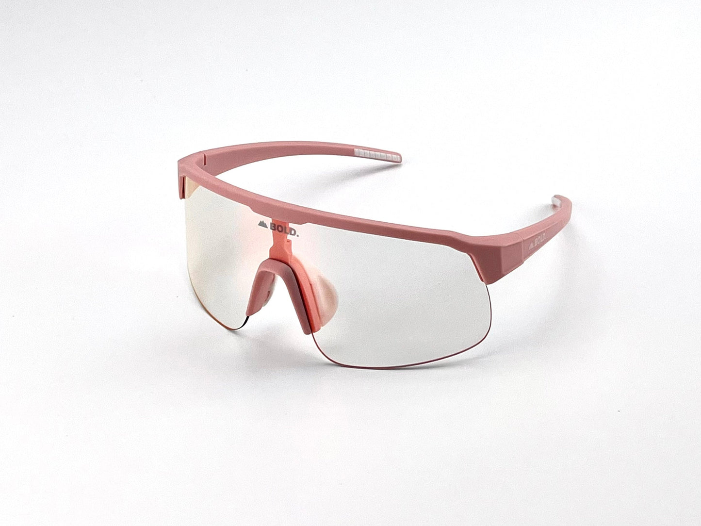 The BOLD Zippy Photochromic Sunglasses from boldouterwear feature a single large mirrored lens, pink frame, nose pads, and arms. Shown on a white surface, they're angled from above and the right side—ideal for MTB, ski & lifestyle use.