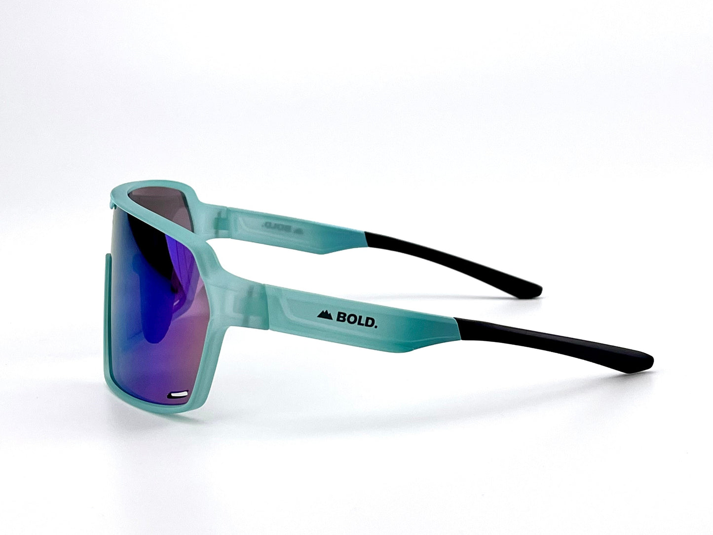 The BOLD Shadows Performance Sunglasses by boldouterwear feature teal translucent frames, black arms with the BOLD. logo and mountain graphic, and large reflective fixed-tint lenses, shown on a clean white background. Ideal for MTB, ski & lifestyle wear.