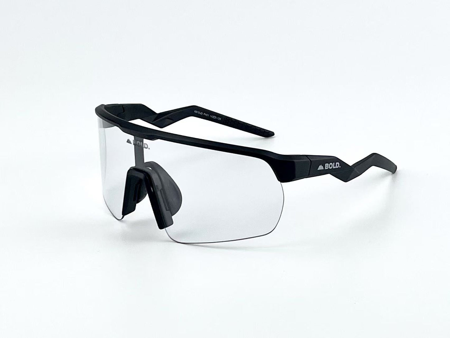 The BOLD Flash Photochromic Sunglasses by boldouterwear feature modern, rimless clear lenses, black angular arms with “BOLD.” in white on the right arm, and a bold black nose pad, all set against a plain white background. Designed for MTB, ski & lifestyle.