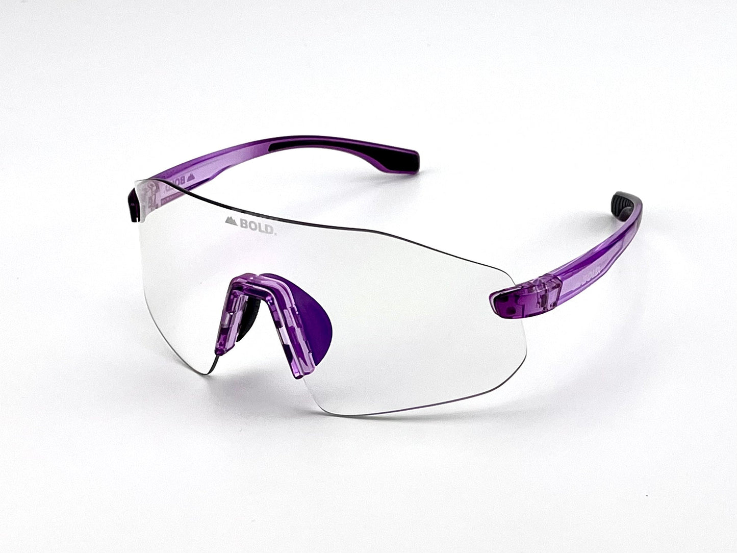 BOLD Emerald Photochromic Sunglasses by boldouterwear feature light-adaptive single curved lenses, purple transparent arms, and a purple nose bridge. The word BOLD. appears on the lens, offering modern clarity for MTB, ski, and lifestyle use.