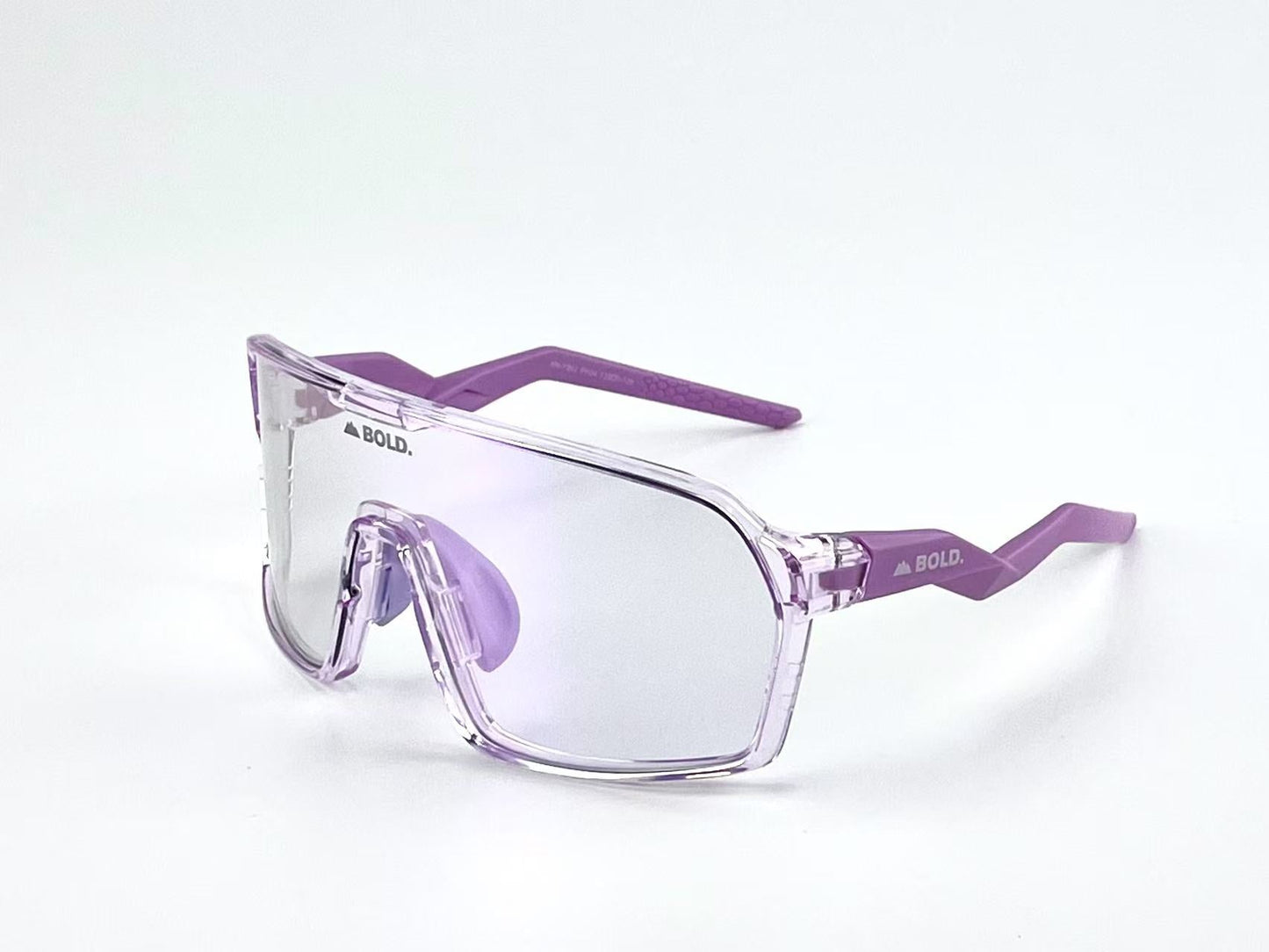 The BOLD Glow Photochromic Sunglasses by boldouterwear feature a transparent purple frame, oversized adaptive design, clear reflective non-polarized lenses, and solid purple arms with “BOLD.” printed near the hinges—all set against a plain white background.