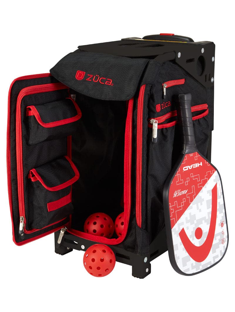 The ZUCA Pickleball Pro Black/Red rolling bag is open, showing handy pockets with orange pickleballs spilling out and a HEAD paddle in the side holder—perfect for keeping your pickleball gear organized.